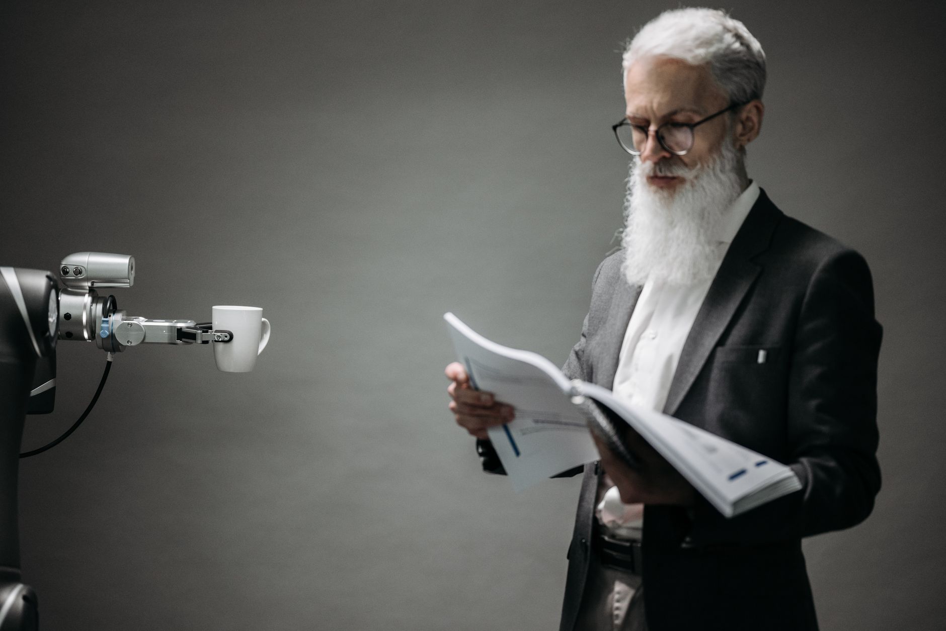 Engineer reviewing documents beside a robotic arm